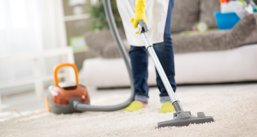 Lady vacuuming the stains on the floor